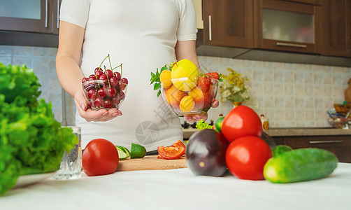 孕妇吃蔬菜和水果 有选择性地集中注意力腹部素食主义者厨房母亲婴儿母性父母怀孕女士横幅图片