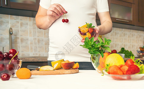 孕妇吃水果 有选择性的专注肚子女士沙拉女性怀孕母性母亲厨房腹部生活图片