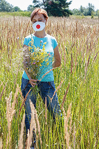 戴保护面罩的妇女持有野花花花束鼻子野花干草过敏花粉季节公园女性女孩发烧图片
