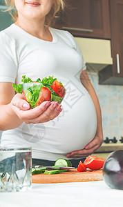 孕妇吃蔬菜和水果 有选择性地集中注意力怀孕女士女孩饮食素食主义者父母横幅母亲腹部婴儿图片