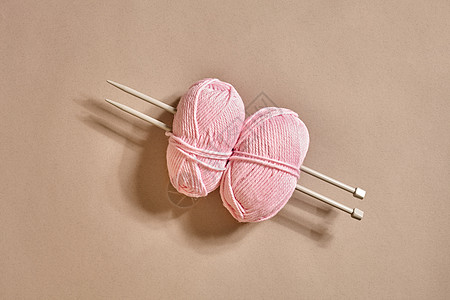 两个粉色编织丝线球 和针织针图片