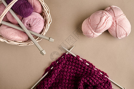 毛线球 柳条盘中的彩色纱线球 用于在米色背景上编织的纱线 针织作为一种针线活 织针和多色纱线看起来很明亮紫色褐线衣服羊毛创造力篮图片