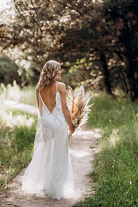 带着一束干鲜花的白光裙子 充满幸福的新娘女孩森林花束树木绿色裤子戏服褐色白色干花小路图片