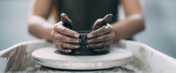 女人的手关紧了 陶瓷大师工作室在陶器轮子上用粘土操作图片
