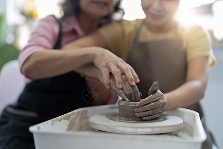 高年级教授年轻的亚洲女性陶器 Clay模特工作工作室勺子陶瓷治疗工具爱好艺术手工桌子图片