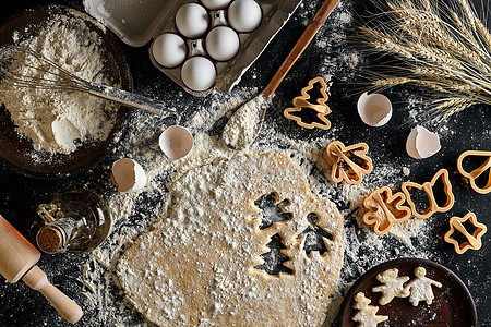 姜汁饼干的口袋卷在桌子上 用模子切开食物平铺烘烤庇护所庆典星星塑料刀具勺子饼干图片