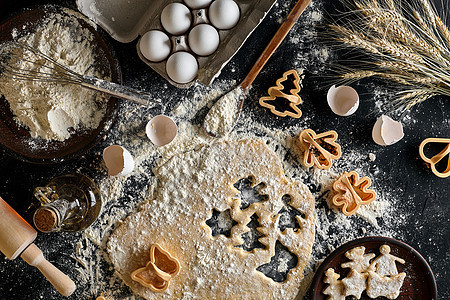 姜汁饼干的口袋卷在桌子上 用模子切开庆典厨房烹饪食物饼干新年烘烤塑料擀面杖面粉图片