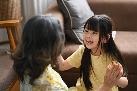 快乐的小可爱女孩喜欢在家里和中年成熟的奶奶一起玩 家庭爱好活动概念图片