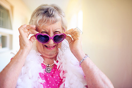 年龄是一个数字 而不是限制 拍摄一位无忧无虑的老妇人在建筑物内部戴上粉红色眼镜微笑幸福灰色成人青年老年退休喜悦太阳镜裁剪图片