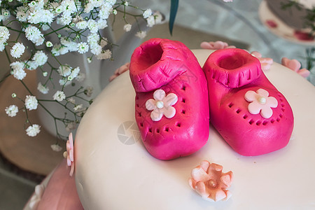 婴儿淋浴蛋糕 为女孩提供粉红马兹潘小靴子和花卉配方图片