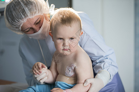 一个小男孩护士治疗烧伤 医院里的一个孩子受伤了 医生治疗婴儿 小医院病人手术疾病儿科衣服拥抱男生护理程序开水医师图片