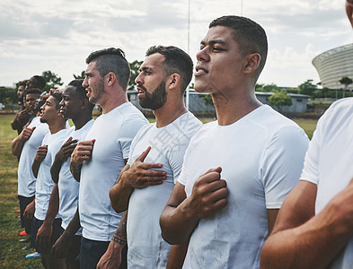 我们已经走到这一步了 在橄榄球比赛前 一群自信的年轻橄榄球运动员在外面的场地上立正唱着他们的国歌图片