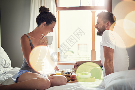 正是这些小事让生活变得美好 一对快乐的年轻夫妇在家里一起在床上享用早餐的镜头图片