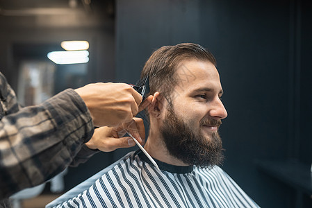 理发店主用剪发机给男人理发修剪胡须男性商业客户剪刀剪子工具理发师造型师图片