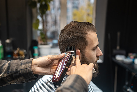 理发店主用剪发机给男人理发成人剪子男性发型设计发型师剪刀客户商业造型师沙龙图片