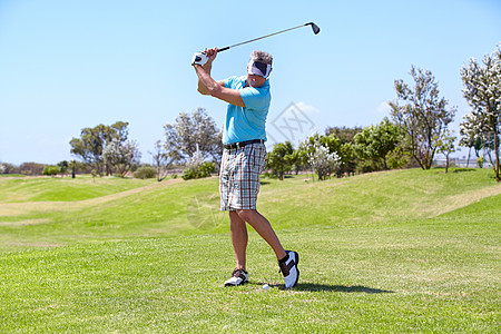 一个在高尔夫球场打高尔夫球的成熟男子男性司机衬衫成人闲暇锻炼驾驶俱乐部休闲运动图片