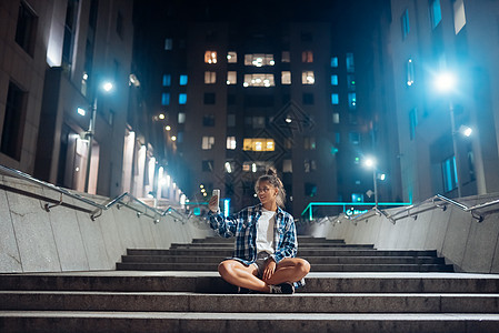 晚上在夜市 有智能手机通过视频电话聊天的女人图片