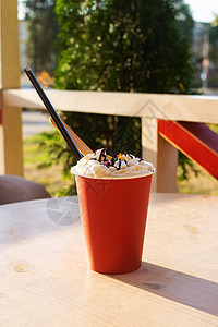 外面的桌子上杯子里一杯咖啡中的香咖啡牛奶热带阳光乡村椅子早餐拿铁饮料餐厅露台图片