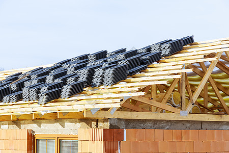 顶部 农舍的木制屋顶结构 板束和金属瓷砖维修工作木头技术建筑学建设者住房装修建筑房子图片