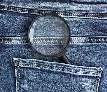 牛仔裤后口袋里的放大器 恒定的搜索概念图片