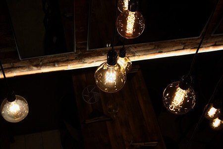 现代餐厅天花板上挂着温暖的玻璃照明灯泡;图片