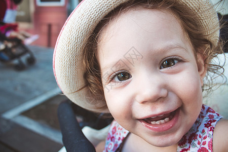 可爱女婴的近视肖像 看着镜头笑着微笑 戴着帽子图片