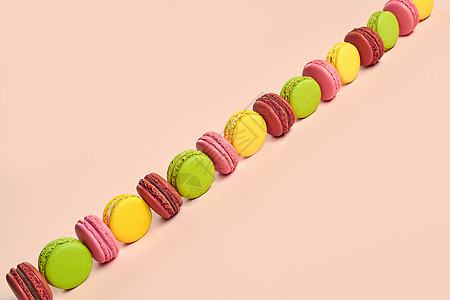 彩色马卡龙或马卡龙 粉红色背景的甜美蛋白调味杏仁酥皮巧克力手工甜点面包味道派对饼干奶油图片