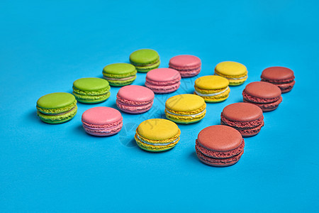 彩色的马卡龙或马卡龙 蓝色背景上的甜美蛋白调味食物奶油糖果巧克力糕点味道面包蛋糕开心果酥皮图片