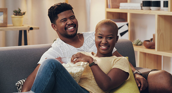 巧克力爆米花拍到一对年轻夫妇在休息室沙发上放轻松的情侣的照片背景