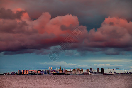 在瓦西里耶夫斯基岛Neva河堤岸正在建造的住宅建筑群中 在日落 散状岛屿和建筑起重机上出现粉红魔法天空建筑学项目海湾财产公寓地面图片