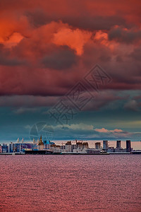 在瓦西里耶夫斯基岛Neva河堤岸正在建造的住宅建筑群中 在日落 散状岛屿和建筑起重机上出现粉红魔法天空碎石运输全景住房财产景观城图片