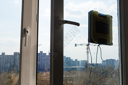 机器人窗户清洁器在脏窗户上工作 用智能设备打扫房子 擦窗自动吸尘机器人 居家好帮手帮助家务帮手机器房间建筑家政刷子器具洗涤图片