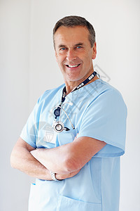 自信的医生用双手交叉反对白色 一位微笑的医生的画象用双手在白色背景下折叠图片