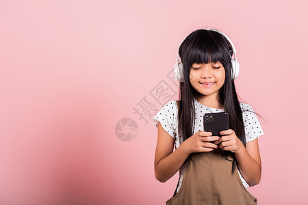 10年的亚洲小孩享受手机音乐 戴着无线耳机闭着眼睛孩子们紫色工作室青春期女孩童年细胞耳机技术女性图片