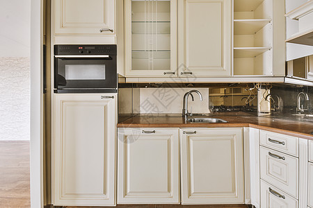 带白色家具的现代厨房内内部住宅龙头烤箱柜台公寓火炉内阁架子房子组织图片