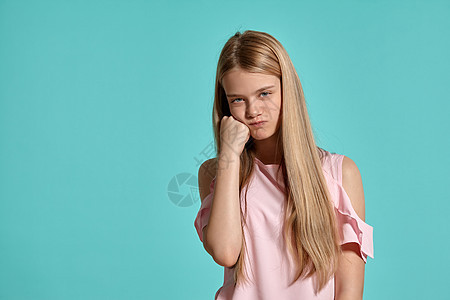 一个穿着粉红色T恤的金发美女少女 穿着蓝色背景装扮的片场肖像学生金发女郎姿势女性青少年女士头发工作室青年孩子图片