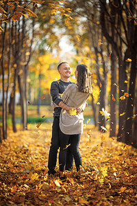 秋叶下秋天公园的秋天公园舞中 年轻夫妇背景图片