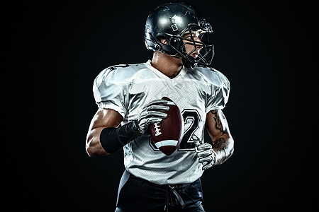 美国橄榄球运动员球员在黑色背景上的头盔 运动和动力 团队竞技联盟体育场黑暗挑战男人游戏男性竞赛训练力量图片