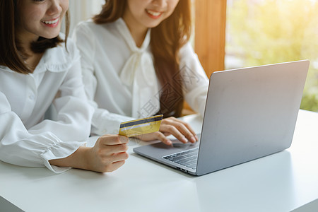 在线购物和互联网支付 美丽的亚洲女性正在使用信用卡和笔记本电脑在数字世界中在线购物或办事成人商业享受幸福信用卡片技术零售银行业互图片