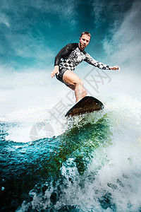 在蓝海中冲浪 年轻人平衡在风筝板上 守夜板上运动冲浪板风景破岸太阳天气风险滑水板热带假期图片
