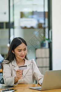 在线购物和互联网支付 美丽的亚洲女性正在使用信用卡和笔记本电脑在数字世界中在线购物或办事互联网女士网上购物摄影信用技术店铺手机幸图片