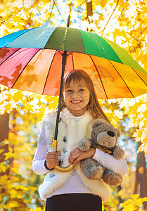 秋天公园的雨伞下的孩子 有选择地集中精神下雨喜悦淋浴婴儿花园乐趣童年季节天气水坑图片