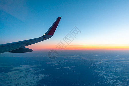 飞机的机翼和地面通过照明器观察到 在空中飞行小翼日出运动日落运输航班涡轮空气飞机场航空图片