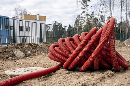 铺设电缆的红色聚氯乙烯管道 装配红波纹聚氯乙烯管道建造接线力量电工金属导管软管管子电气工程图片