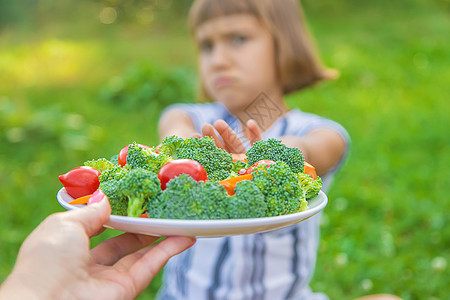 蔬菜沙拉手写字儿童吃蔬菜花椰菜和胡萝卜 有选择性的焦点孩子们桌子沙拉花园女孩童年营养围裙厨房眼镜背景