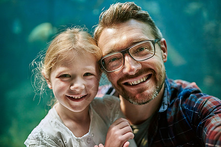 父亲和他的女儿的肖像 在水族馆一起拍自拍 然后在水族馆里跳着舞来跳去图片