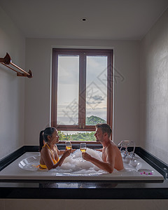 在泰国日落时 男女在浴池露泡中图片