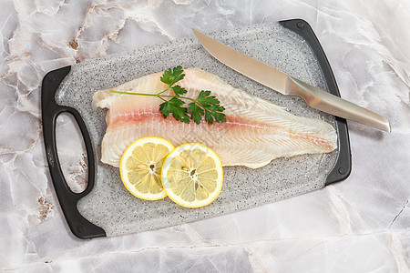 香料鱼的毛片 切板上有鹦鹉叶美食木头柠檬香菜烹饪鱼片食物桌子厨房海鲜图片