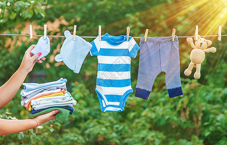 洗婴儿衣物 在新鲜空气中干枯床单 有选择的焦点乐趣洗衣边界衣服篮子男生母亲亚麻女孩衣绳图片