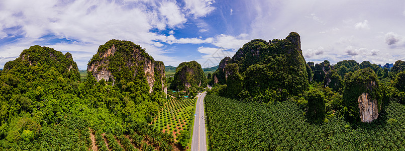 泰国Krabi棕榈树和石灰岩山之间交通畅通的美丽道路天空沥青场景街道公园树木场地蓝色热带石头图片